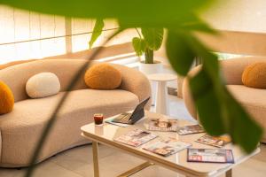 Peramis Hotel & Spa في أنطاليا: غرفة معيشة مع أريكة وطاولة مع الكمبيوتر المحمول