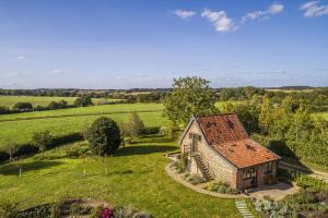 an aerial view of a stone house in a field at Granary Cottage in Wenhaston