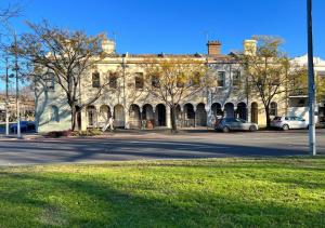 a large stone building with cars parked in front of it at Victorian Terrace in the heart of it all! in Melbourne