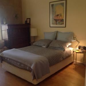 a bedroom with a bed and a lamp on a wooden floor at Strawbale House Bacchus Marsh in Bacchus Marsh