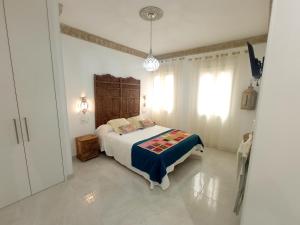 1 dormitorio con 1 cama en una habitación blanca en Los encantos de Almavir, en Córdoba