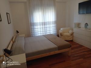 een slaapkamer met een bed en een stoel bij Nel mezzo del cammin in Brindisi