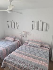 1 Schlafzimmer mit 2 Betten und 2 Spiegeln in der Unterkunft Apartamento cerca de la playa in Almería