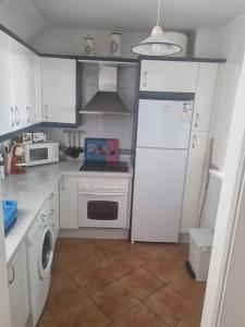 eine Küche mit weißen Geräten und einem weißen Kühlschrank in der Unterkunft Apartamento cerca de la playa in Almería