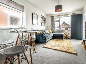 a living room with a couch and a table and chairs at Modern and comfortable home near the river with parking in Exeter