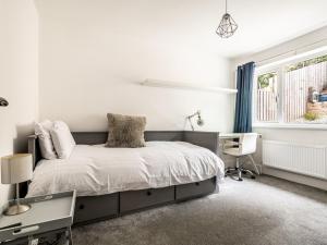 a bedroom with a bed and a desk and a window at Modern and comfortable home near the river with parking in Exeter