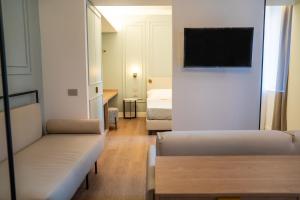 a living room with a couch and a television on a wall at Albergo Bianchi Stazione in Mantova