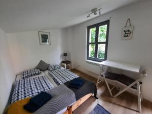 2 camas en una habitación con escritorio y piano en A la maison - épp mint otthon, en Szentbékkálla