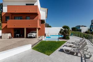 una casa con un coche aparcado delante de ella en ALTIDO Elegant villa with dual pools in Carnaxide, en Carnaxide