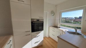 a kitchen with white cabinets and a sink and a window at Haus Sonnenburg in Dahlem