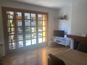 a living room with a large window and a television at Apartamento Refugi in Canillo