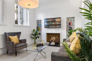 - un salon avec un canapé et une table en verre dans l'établissement Harrods 2 Bed Lux Flat w/patio, à Londres