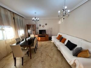 salon z białą kanapą i jadalnią w obiekcie Casa grande de tres plantas w mieście Linares