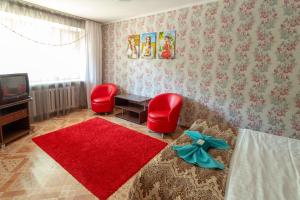 a living room with two red chairs and a television at Киев in Petropavlovsk