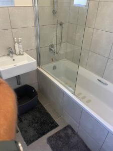 a bathroom with a shower and a tub and a sink at 62 The Shades in Durban