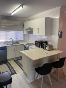 a kitchen with a counter and some chairs in it at 62 The Shades in Durban