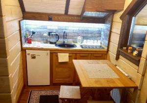 uma pequena cozinha com um lavatório e uma mesa em Еко будинок в горах em Verkhniy Bystryy
