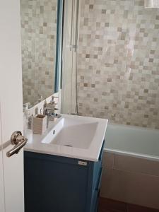 La salle de bains est pourvue d'un lavabo blanc et d'une baignoire. dans l'établissement Lyrioshomes Apartamento Filpo Rojas , Sevilla, à Séville