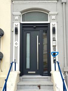 a black front door of a building with blue gates at 2 Beach House in Bridlington