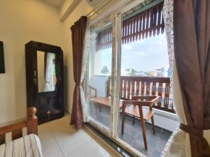Cette chambre dispose d'un balcon avec une chaise et une fenêtre. dans l'établissement RVS Chalet, à Pondichéry
