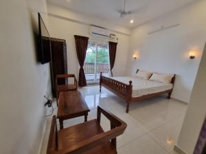 a living room with a bed and a table at RVS Chalet in Puducherry