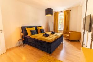 ein Schlafzimmer mit einem großen Bett mit gelben Kissen in der Unterkunft *4 Personen, 2 Zi, zentrumsnah* in Pirna