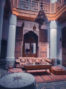 uma sala de estar com um sofá e uma mesa em Ryad Zahrat Fes em Fez