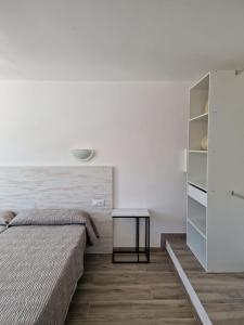 sypialnia z łóżkiem i stołem w obiekcie Aparthotel Puerto Cala Vadella w mieście Cala Vadella