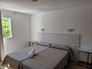 a bedroom with a bed with a stuffed animal on it at Aparthotel Puerto Cala Vadella in Cala Vadella