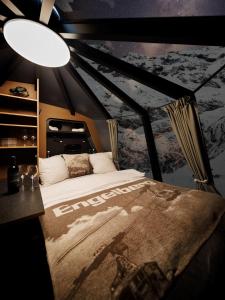 a bedroom with a large bed with a poster on the wall at Berghotel Trübsee in Engelberg