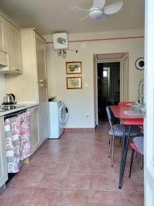 cocina con mesa, mesa roja y sillas en Foresteria San Niccolo' 14 en Prato