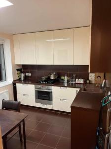 een keuken met witte kasten en een fornuis met oven bij Dainai Apartments in Šiauliai