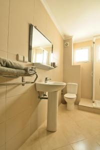 ein Badezimmer mit einem Waschbecken, einem WC und einem Spiegel in der Unterkunft Appart Hôtel Founty Beach in Agadir