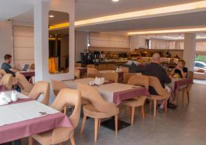 two people sitting at tables in a restaurant at Peramis Hotel & Spa in Antalya