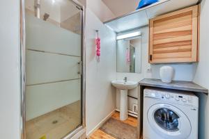 uma pequena casa de banho com uma máquina de lavar roupa e um lavatório em Le Mendès France - Région parisienne em Vauréal