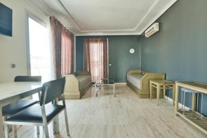 una sala de espera con sillas, una mesa y una ventana en Appart Hôtel Founty Beach, en Agadir