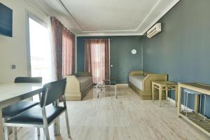 - une salle d'attente avec des chaises, une table et une fenêtre dans l'établissement Appart Hôtel Founty Beach, à Agadir