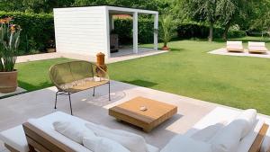 a patio with a couch and a coffee table at B&B Maison La Belle in Zoutleeuw