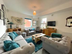 Lovely Comfortable 3BR Property في Nether Edge: غرفة معيشة مع كنبتين وتلفزيون