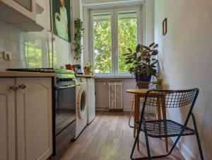 una cucina con lavatrice, tavolo e sedia di Cozy Park Apartment a Budapest