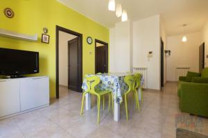 une salle à manger avec une table et des chaises vertes dans l'établissement Appartamento Fontana Greca 4 ,Gallipoli, à Gallipoli