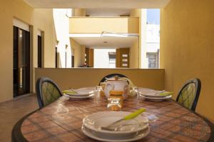 - une table avec des assiettes et des ustensiles en haut dans l'établissement Appartamento Fontana Greca 4 ,Gallipoli, à Gallipoli