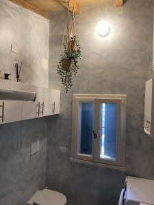 uma casa de banho com um WC e uma janela em Alloggio con camino nel borgo del castello em Albinea