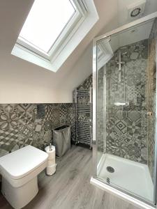 a bathroom with a toilet and a glass shower at Lovely Comfortable 3BR Property in Nether Edge