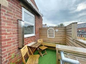 a patio with a wooden table and bench on a balcony at Lovely Comfortable 3BR Property in Nether Edge