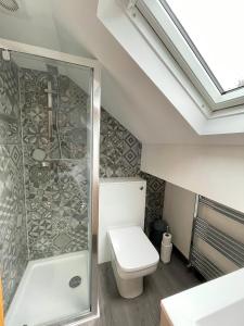 uma casa de banho com um WC e um chuveiro em Lovely Comfortable 3BR Property em Nether Edge