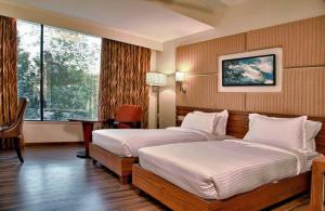 um quarto de hotel com duas camas e uma janela em Staynest gangtok 300 mtr from MALL ROAD em Gangtok