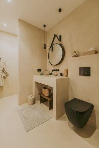 baño con aseo negro y espejo en Villa 3 chambres Piscine - Golf, en Marrakech