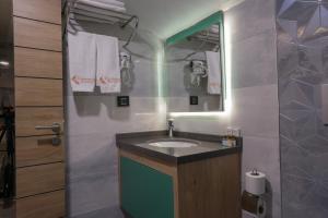 a bathroom with a sink and a mirror at Peramis Hotel & Spa in Antalya