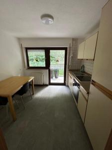 a small kitchen with a table and a table and a window at HW2 Drei Zimmer Wohung 80qm in Königsbronn